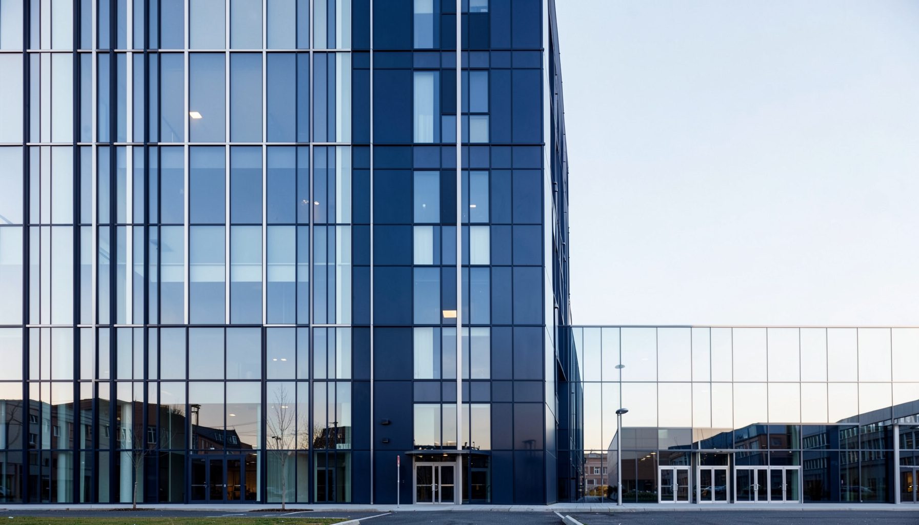 Modern glass-and-steel building facade in deep navy blue with strong symmetrical lines